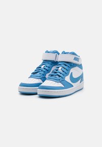 Nike high-top sneakers feature a white leather base with light blue accents, a padded cuff, and a Velcro strap. Perforated toe box for breathability.