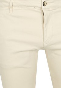 Beige denim jeans met een aansluitend ontwerp, sluiting met een knoop aan de voorkant en een ritssluiting. Stijlvolle textuur met minimale stikdetails.