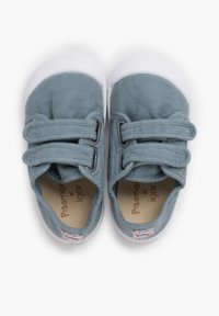 Chaussures de tout-petits bleu clair avec des semelles blanches et deux bandes Velcro, placées soigneusement sur un fond blanc.