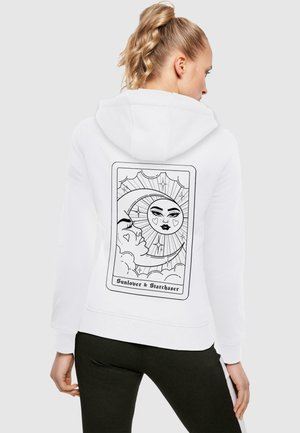 Hvid hoodie med en sort linjetegning af en sol og måne inden i et rektangel på bagsiden. Materialet ser blødt og tekstureret ud.