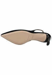 Zapato de tacón alto negro con punta afilada, acabado en charol y suela beige. Presenta una silueta elegante y mínimas acentuaciones de hardware.
