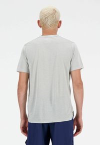 Grijze T-shirt met korte mouwen en een textuurpatroon. Beschikt over een ronde halslijn en een rechte zoom, gedragen met marineblauwe shorts.