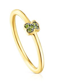 Złoty pierścionek z małym wzorem w kształcie misia, ozdobiony pięcioma zielonymi kamieniami szlachetnymi na gładkiej, smukłej obrączce.