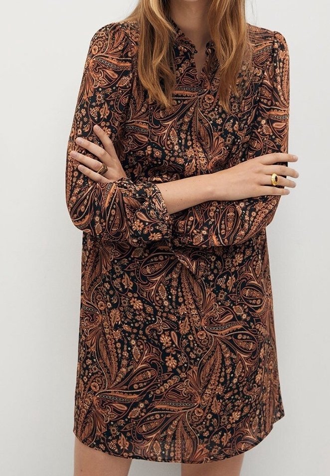 Robe à manches longues en tissu sombre avec un motif paisley complexe dans des nuances d'orange et de marron, dotée d'un col et d'une coupe décontractée.