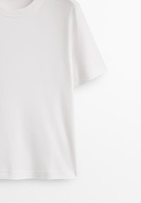 White cotton t-shirt featuring short sleeves, a classic crew neck, and a smooth texture with no visible patterns or embellishments.