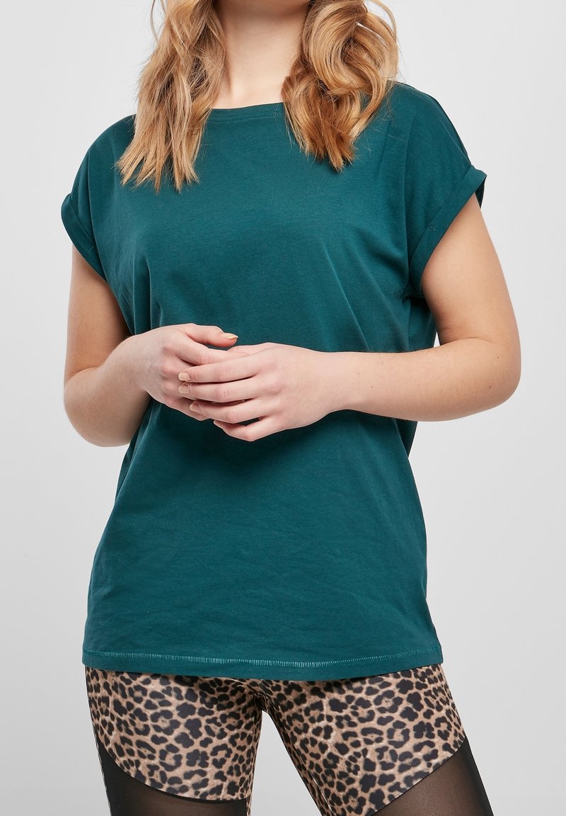 T-shirt en coton turquoise à manches retroussées, associé à un legging imprimé léopard. T-shirt avec une coupe décontractée et un col rond.