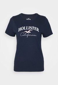 Námořnické bavlněné tričko s krátkým rukávem, s bílým vyšívaným textem "HOLLISTER" a "California" a malou ptáčkovou nášivkou.