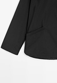 Zwarte lange mouwen jas met zichtbare manchetten en een zijzak, geïsoleerd op een witte achtergrond.