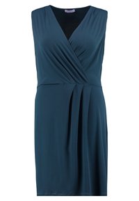 Ärmlös turkos klänning med djup V-ringning, rynkning i midjan och rak skärning. Gjord av mjukt, lätt tyg med draperad effekt.
