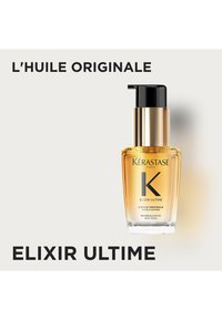 Huile capillaire Kérastase Elixir Ultime dans un flacon en verre transparent contenant un liquide doré. Présente un bouchon-pompe noir et un design d'étiquette minimaliste.