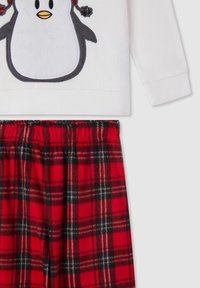 Białe polarowe podkoszulki z motywem pingwina, ozdobione czarnymi i pomarańczowymi haftami, w komplecie z czerwonymi i czarnymi spodniami flanelowymi w kratę, z elastycznym pasem.