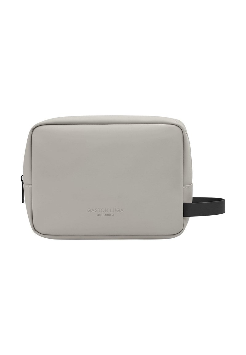 Gray rectangular bag made of smooth material, featuring a black strap and embossed brand name on the front. Zipper closure at side.