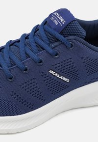 Baskets Jack & Jones bleu marine avec tige en mesh, languette et côté marqués, fermeture à lacets, semelle blanche texturée.