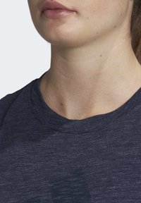 Námorně modré tričko s krátkým rukávem, vyrobené z jemné, strukturované tkaniny, s kulatým výstřihem a jemným heather vzorem.