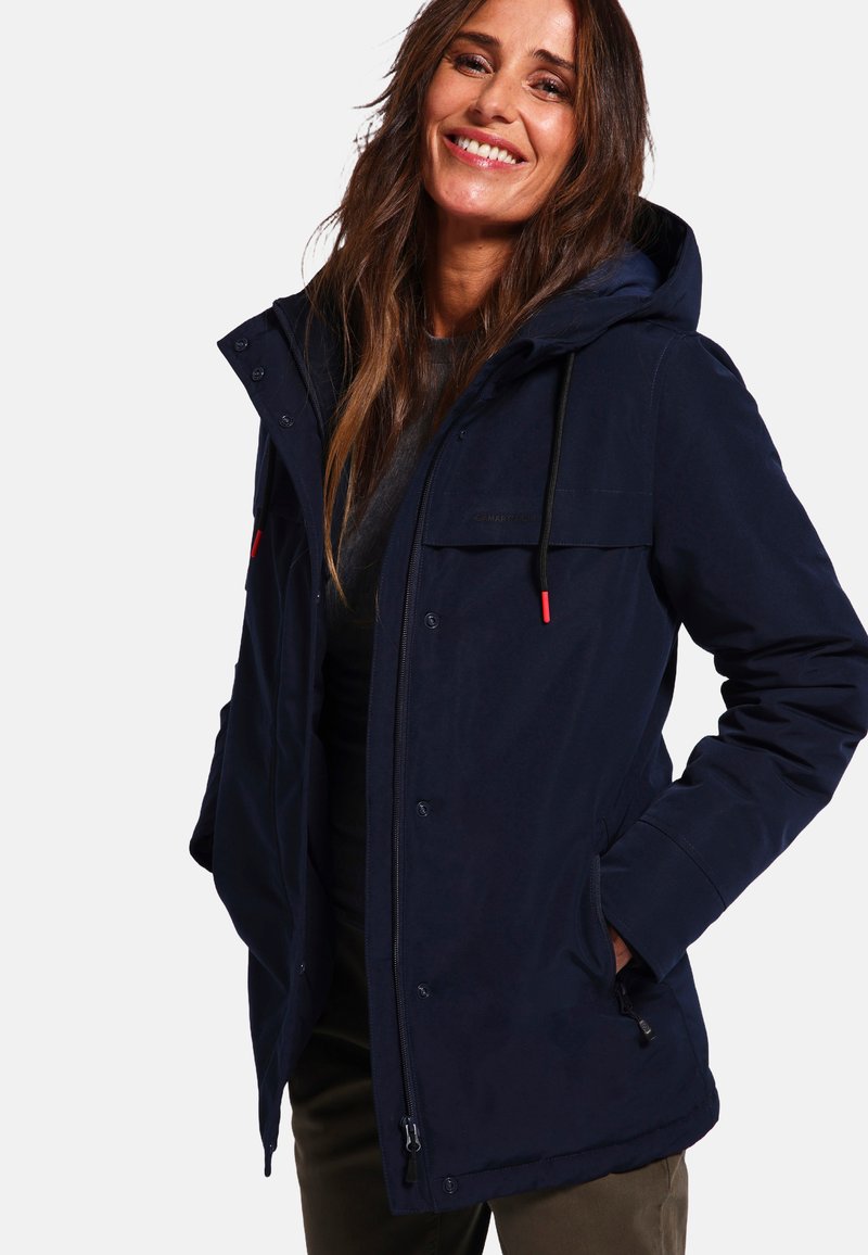 Veste d'extérieur bleu marine avec capuche, dotée d'une fermeture éclair et de boutons, de deux poches avant, et de cordons de serrage noirs avec des accents rouges.