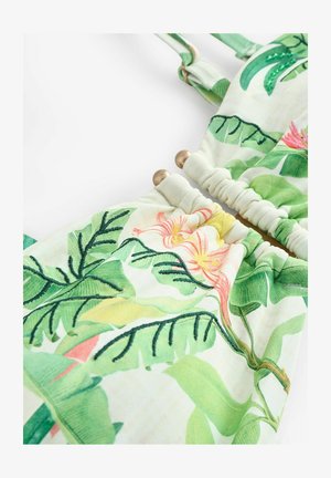 Tkanina s cvetličnim vzorcem z zelenimi listi, rožami v roza in rumeni barvi, z nabranim dizajnom in zlatimi kovinskimi detajli. Mehka tekstura.