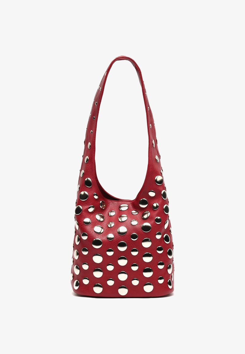 Bolso de hombro de cuero rojo con grandes y pequeños tachuelas circulares plateadas cubriendo la parte frontal y la correa, sobre un fondo blanco.