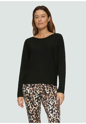 Schwarzer gerippter Pullover mit langen Ärmeln, rundem Halsausschnitt und strukturiertem Muster, kombiniert mit einer Hose im Leopardenmuster mit glatter Oberfläche.