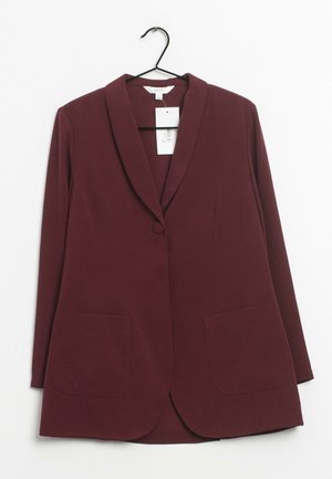 Blazer femme rouge foncé à manches longues, fermeture à un bouton, deux poches avant, suspendu sur un cintre noir sur fond blanc.