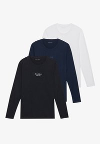Three long-sleeve t-shirts in black, navy, and white, featuring round necklines and text graphic on the black shirt. Soft cotton fabric.