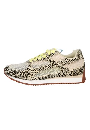 Zapatilla de perfil bajo con cordones amarillos, malla beige y patrón de manchas negras sobre fondo crema, con entresuela blanca y suela marrón.