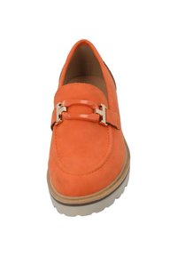 Zapato slip-on de ante naranja con puntera redonda, que presenta un acento de hebilla en tono dorado y una suela de goma texturada.