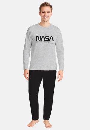 Maglietta grigia a maniche lunghe con testo nero "NASA" e design dello slogan, abbinata a pantaloni neri. Fit semplice e casual; il tessuto sembra morbido.