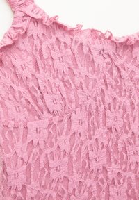 Růžová krajka s květinovým vzorem a texturovaným, vrstveným designem. Okraje jsou volánkové, což dodává detail do oděvu.
