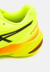 Scarpa da corsa gialla brillante con tomaia testurizzata, accentuata in nero e gradiente arancione sulla suola. Presenta il marchio della tecnologia FlyteFoam.