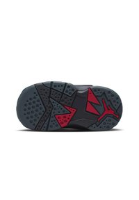 Semelle de basket noire avec accents rouges. Présente un caoutchouc texturé avec des motifs circulaires et triangulaires. Logo signature embossé.