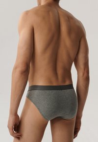 Szare bawełniane majtki z ciemnym elastycznym paskiem w talii, prezentujące dopasowany krój i gładką fakturę, widok z tyłu.