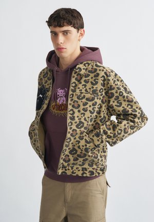 Bunda so vzorom leopardej potlače z odolnej látky, s predným zipsom, bočnými vreckami a kontrastnou kapucňou v tmavej burgundskej farbe pod ňou.