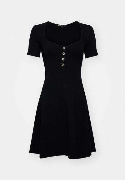 Rochie neagră din tricot, cu corset ajustat, mâneci scurte, decolteu pătrat și fusta evazată. Prezintă închideri decorative cu nasturi.