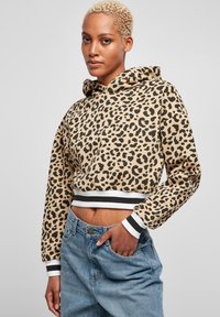 Kuttet hettegenser i beige med svart leopardmønster, med snorhette og kontrasterende svart og hvit ribbestrikkede mansjetter og linning.
