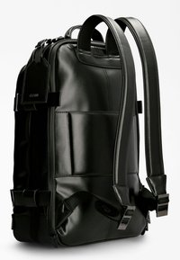 Svart ryggsäck i glänsande syntetiskt material. Har vadderade justerbara axelremmar, flera fickor och eleganta metalldetaljer.