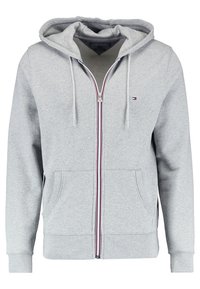 Grauer Zip-Hoodie mit einem Frontreißverschluss, zwei Taschen, Kordeln und einem kontrastierenden roten und blauen Akzent am Reißverschluss. Aus Baumwollmaterial.