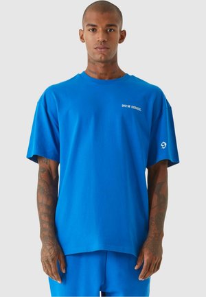 Blaues Baumwoll-T-Shirt mit kurzen Ärmeln, einem Rundhalsausschnitt und einem weißen bedruckten Logo auf der linken Brust. Verfügt über eine entspannte Passform und eine glatte Textur.