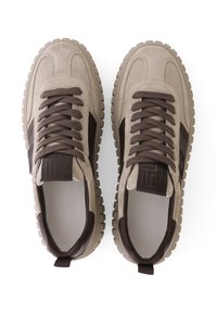 Baskets en daim beige avec des accents marron foncé, des lacets texturés et une étiquette avec un logo à motif sur la languette ; semelle en caoutchouc avec un design strié.