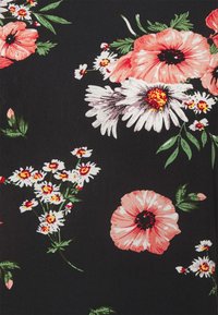 Blommönstrad tyg med stora rosa och vita blommor med svarta mittpunkter, på en svart bakgrund. Små vita prästkragar insprängda.