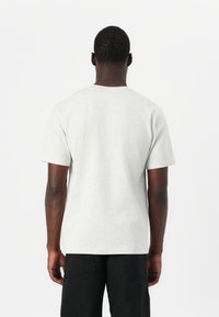 Gray cotton t-shirt with a crew neck and short sleeves. The fabric appears soft with a smooth texture and a relaxed fit, positioned against a blank background.