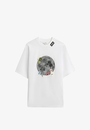 Weißes T-Shirt mit einem großen Mondmotiv, umgeben von kleinen, bunten, bestickten Patches und einem schwarzen "PEACE"-Etikett in der Nähe des Halsausschnitts.