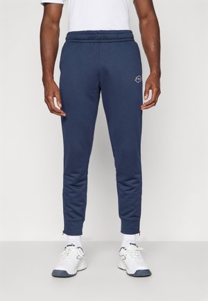 Navyblaue Jogginghosen mit einem gerippten Bund, schmal zulaufenden Beinen, Reißverschlüssen an den Knöcheln und einem dezenten Logo am linken Oberschenkel. Hergestellt aus glattem Stoff.