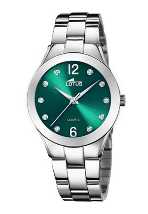 Stříbrné kovové náramkové hodinky se zeleným ciferníkem, krystalovými indexy hodin a stříbrnými ručičkami ukazujícími čas 10:09:38, značky "Lotus Quartz."