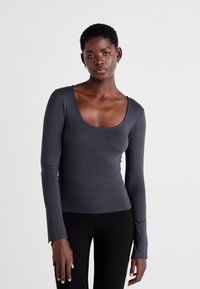 Long-sleeve, scoop-neck top in dark gray, made of stretchy fabric. Features a fitted silhouette and slightly flared sleeve hems.
