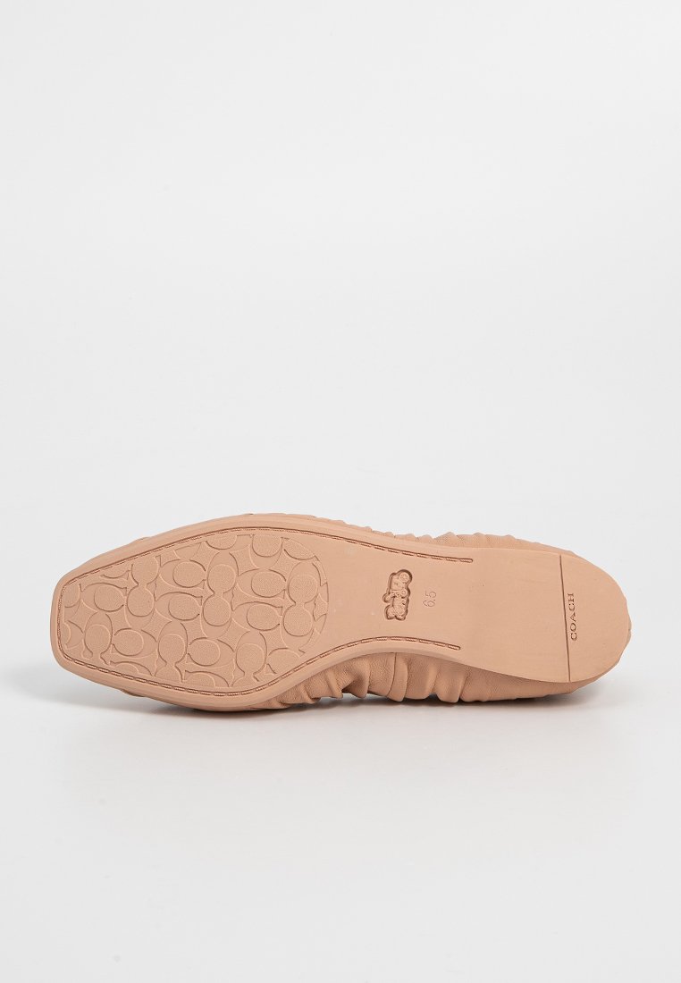 Lichtbruine rubberen zool met een gestructureerd oppervlak en een afgeronde vorm. Bevat een logo en een flexibele randontwerp voor comfort.