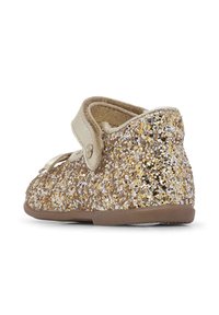 Dziecięce buty w kolorze złotym i srebrnym z brokatem, o zaokrąglonym kształcie, z miękkim beżowym paskiem i powierzchnią z teksturowanego brokatu, z brązową gumową podeszwą.