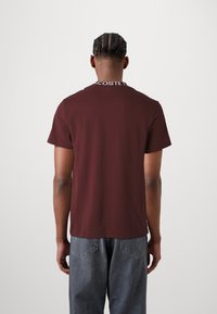 Lacoste CORE ACTIVE - Nyomott mintás póló - expresso