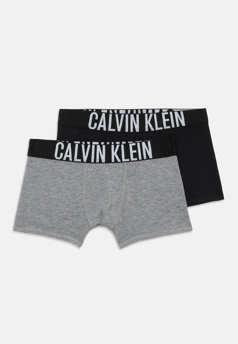 Două perechi de boxeri Calvin Klein, una gri deschis și una neagră, cu brațe negre care prezintă textul alb al logo-ului.