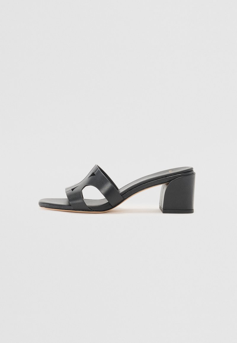 Sandali a soffietto neri in pelle con tacco a blocco, caratterizzati da una punta aperta e tagli laterali, con una texture liscia e un design minimale.