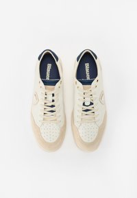 Adidași albi și beji cu un design texturat, având perforații, accente din suede bej și o limbă din țesătură albastră cu marca "Blauer".
